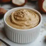 Creamy tahin paste in a bowl with sesame seeds.